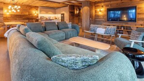 A modern living room with a sectional sofa, a TV, and a wooden interior.