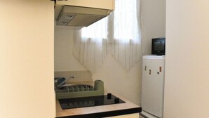 Una cocina compacta con un fregadero, un microondas y un refrigerador.