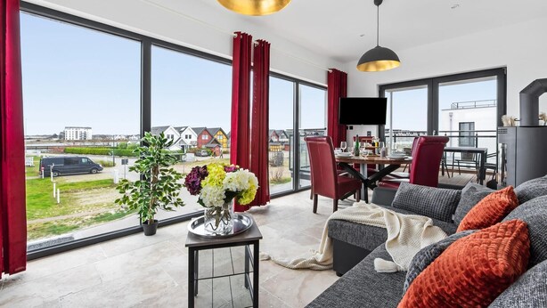 A modern living room with large windows, a dining area, and a fireplace. - Pet friendly apartment in Olpenitz (Olpenitz)