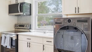 Una cucina moderna dotata di forno a microonde, forno e lavatrice.