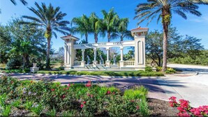 Una entrada cerrada con un letrero que dice "Emerald Island Resort", rodeada de palmeras y un jardín ajardinado.