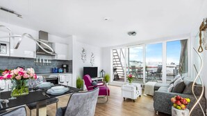 Een modern appartement met keuken, eethoek en woonkamer.