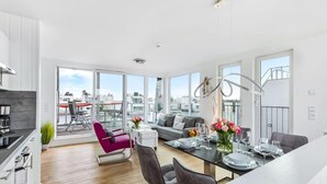Een modern appartement met keuken, eethoek en woonruimte, met grote ramen.