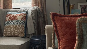 A cozy living room with a sofa, a chair, a chandelier, and a bookshelf with framed photos. - Wellness Gardens Retreat

 (Sidney)