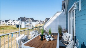 Une terrasse avec des sièges, une machine à café et des plantes en pot.