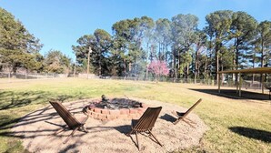 A backyard with a fire pit, two chairs, and a covered seating area. - 
Lake Sweet Hut by Lake Texoma-B
 (Pottsboro)
