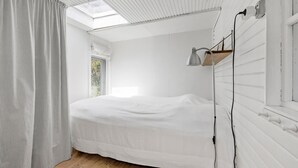 A bedroom with a skylight, a bed, a bedside table, and a lamp. - 2 bedroom lovely home in Jægerspris (Jægerspris)