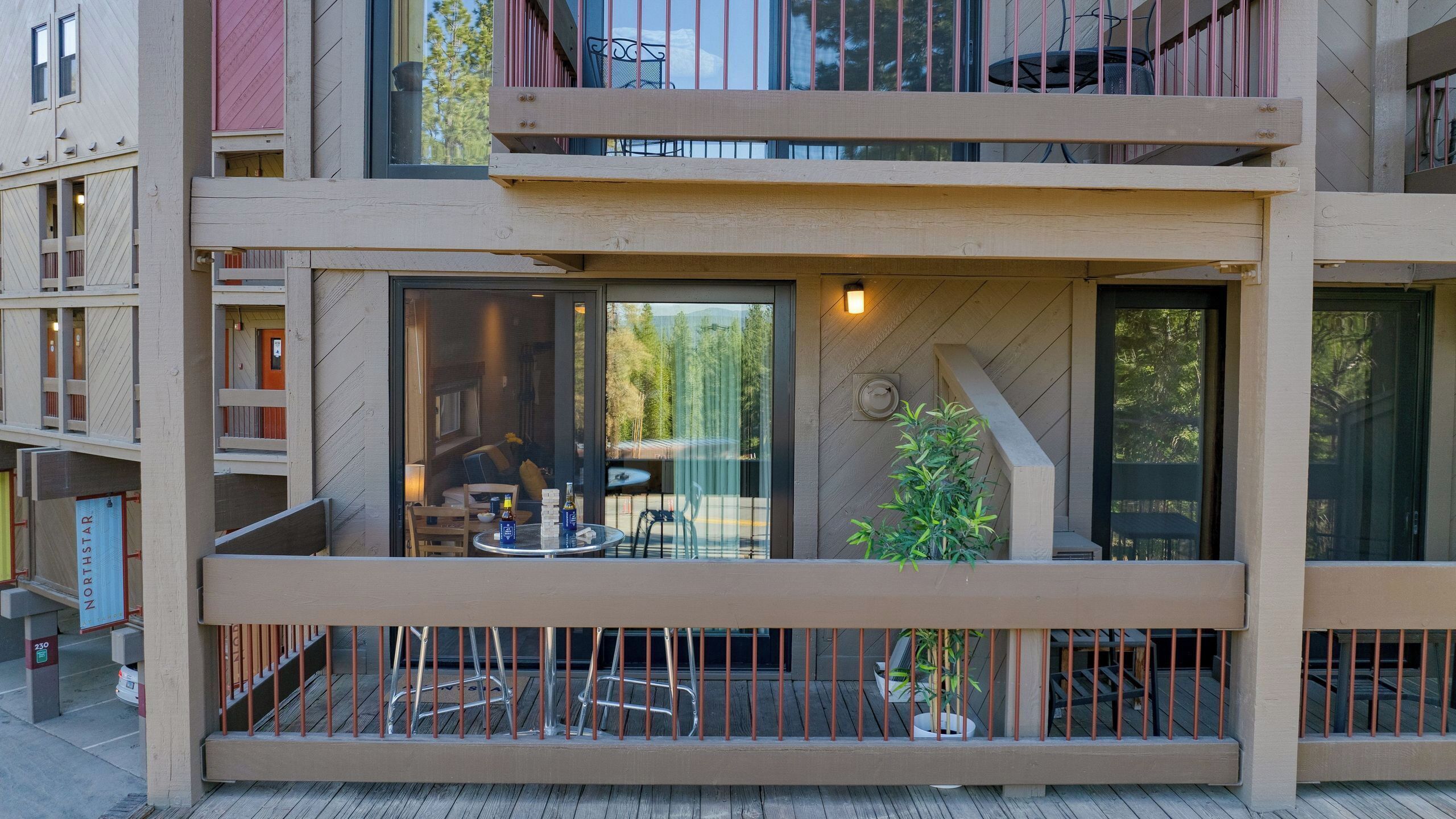 A modern multi-story building with balconies, large windows, and outdoor seating.
