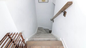 Un escalier avec des rampes en bois et une plateforme recouverte de moquette.