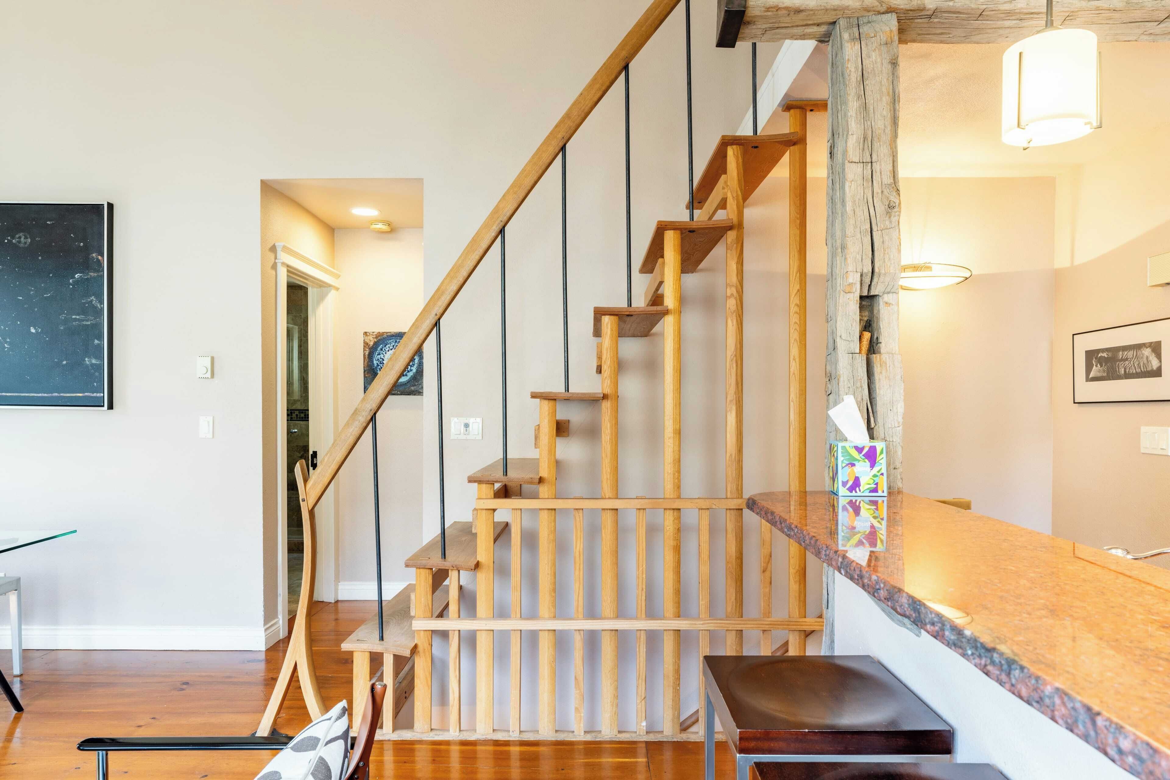 A wooden staircase with a marble countertop and a bench at the bottom.