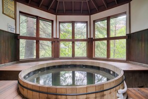 A wooden hot tub with a glass bottom, surrounded by wooden benches and large windows offering a view of trees. - Manitou River House 113 by Avantstay A+ Location (Telluride)