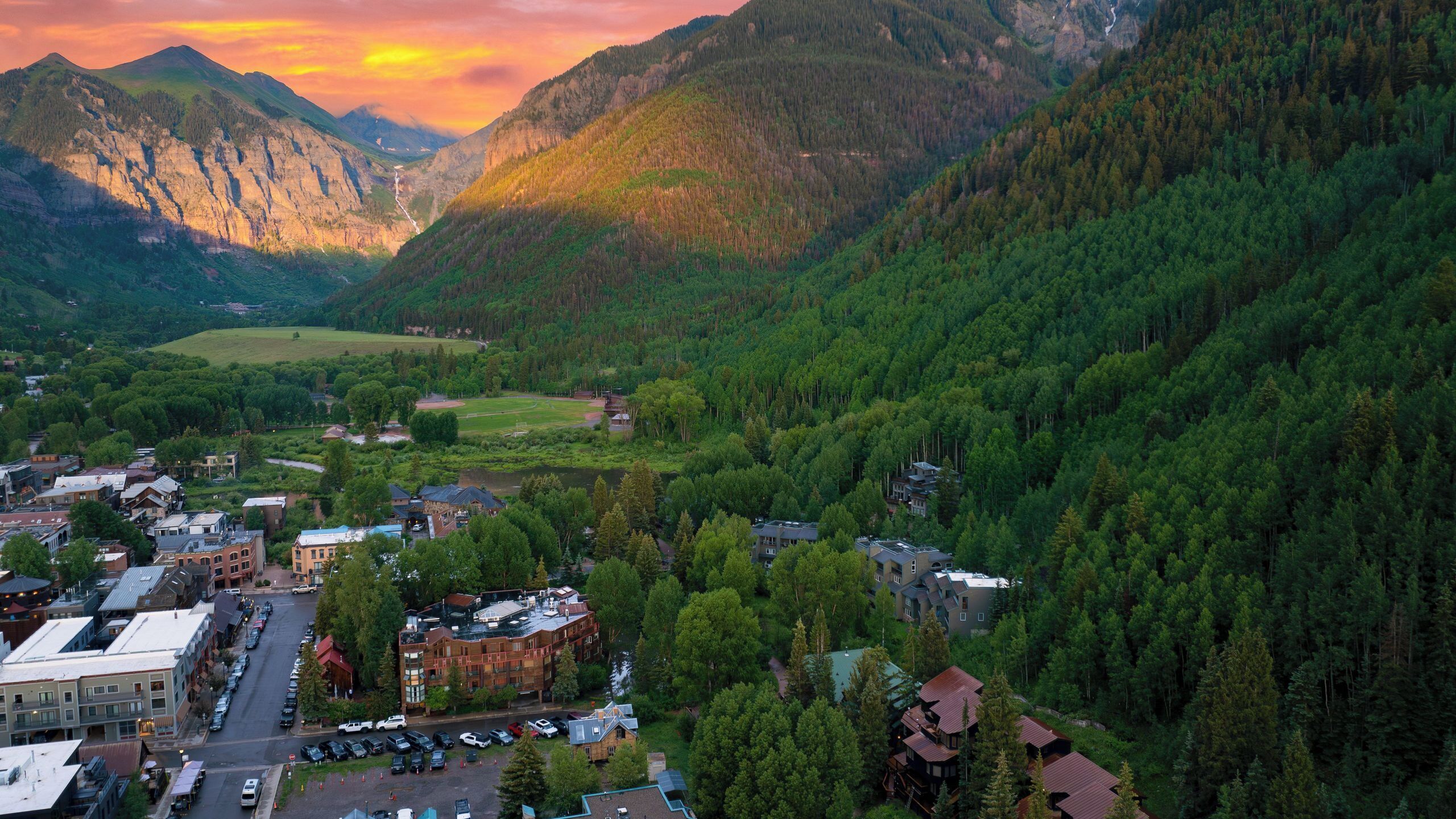 Une ville nichée dans une vallée, avec des montagnes en toile de fond, où se côtoient des bâtiments résidentiels et commerciaux.