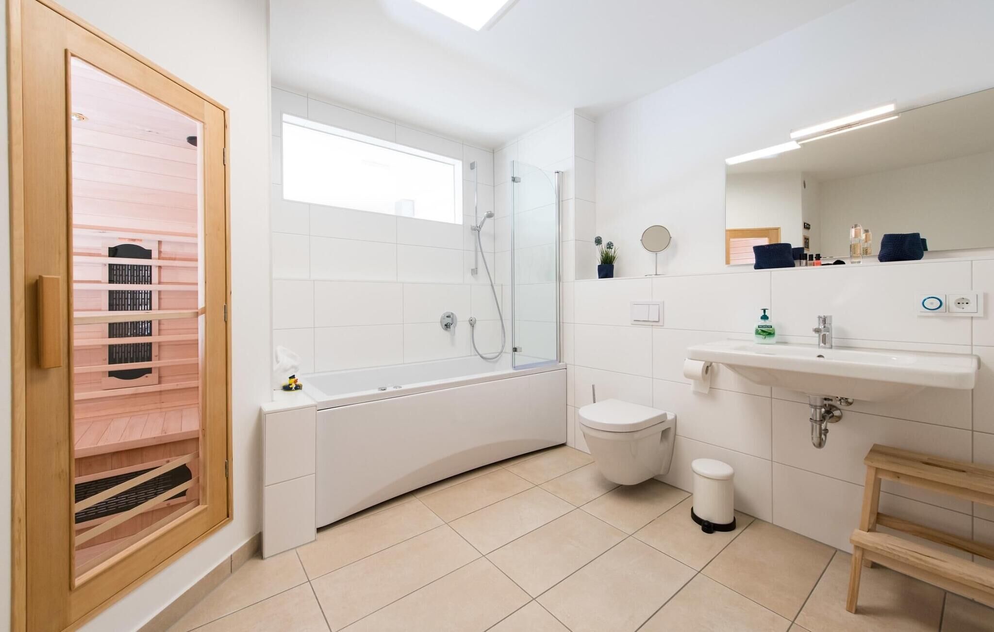 Une salle de bain moderne équipée d’une baignoire, d’une douche, de toilettes et d’un lavabo.