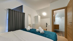 A hotel room with a bed, a wardrobe, a mirror, and a bathroom visible through an open door. - 2 bedroom cozy home in Margecan (Margecan)