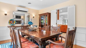 Une salle à manger avec une table en bois, des chaises et un vase décoratif.