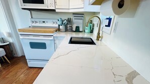 Eine Küche mit weißen Schränken, einer Mikrowelle, einem Toaster und einem Spülbecken.