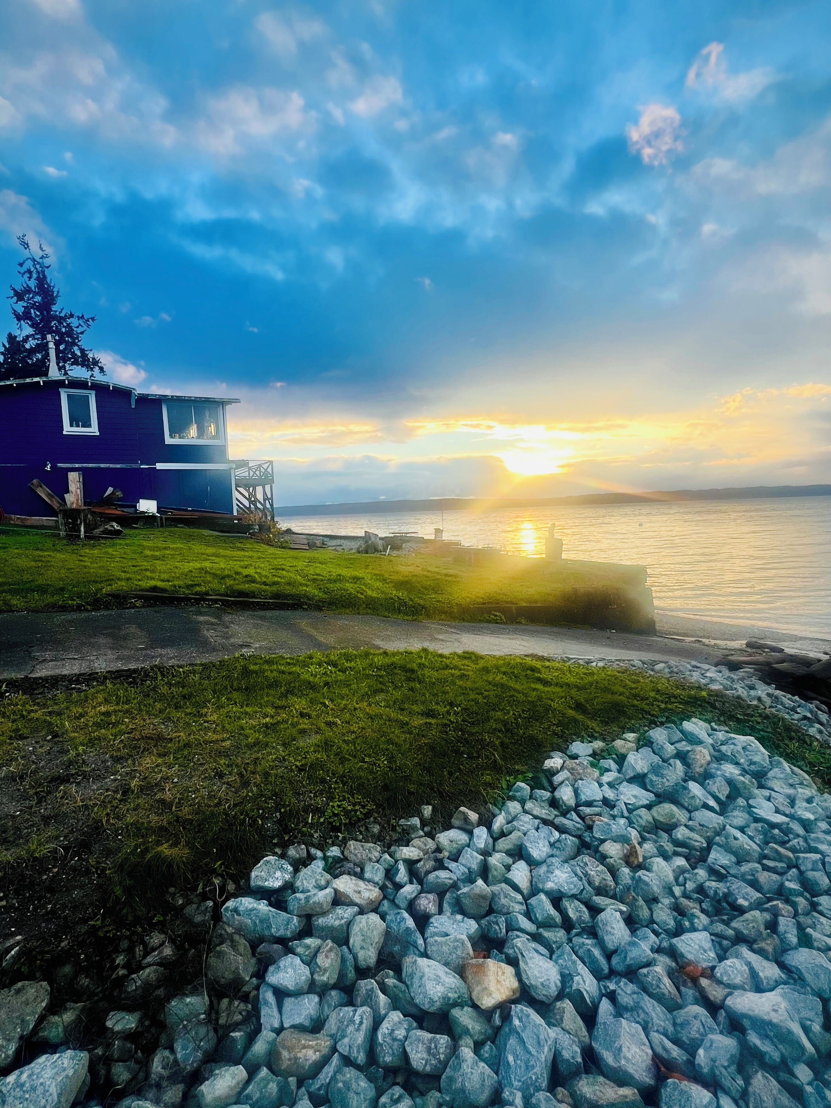 A house with a view of the sunset over a body of water.