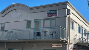 Un motel amb una zona de recepció i un balcó amb cadires.