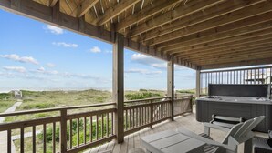 A wooden deck with a view of the beach, outdoor seating, and a hot tub. - 7865- Peridot, Oceanfront 5 bedroom home in Frisco! (Frisco)