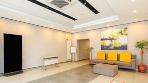A modern lobby with a grey sofa, a bench, and a large abstract painting on the wall. - Taishangdeng Hotel (Beijing Daxing Huangyi Road Public Security University Branch) (Beijing)