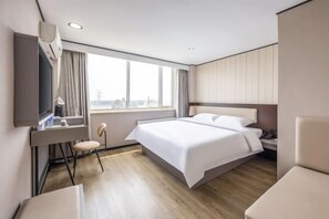 A modern hotel room with a large bed, a desk with a chair, a TV, and a window with a city view. - Taishangdeng Hotel (Beijing Daxing Huangyi Road Public Security University Branch) (Beijing)
