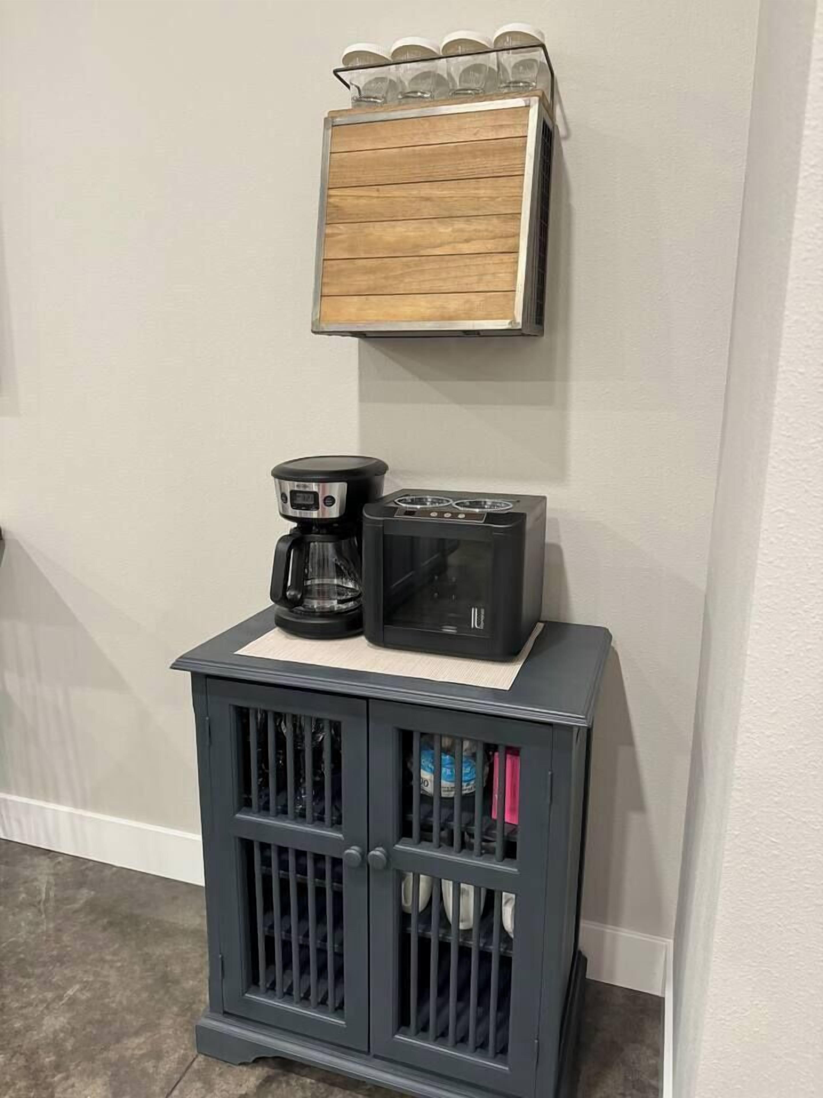 A kitchenette with a coffee maker, toaster, and a small shelf above.