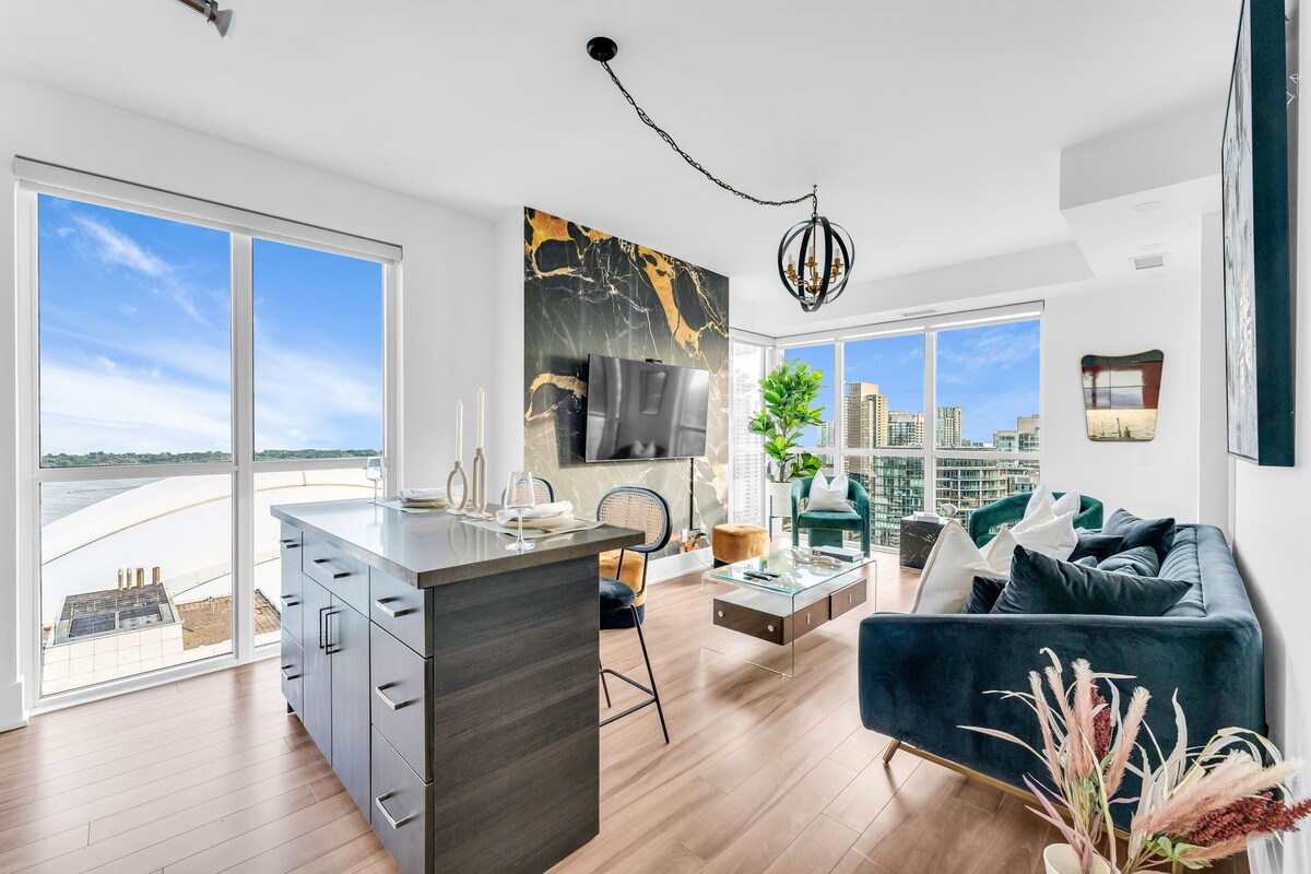 A modern living space with a kitchen, dining area, and a sofa set.