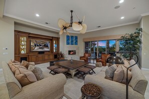 Un salón amplio con chimenea, asientos cómodos y un ventanal con vistas panorámicas.