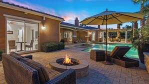 An outdoor patio with a fire pit, lounge chairs, and a swimming pool. - Villa Paradiso - 2 Pools, 5 Suites & More! (Indio)