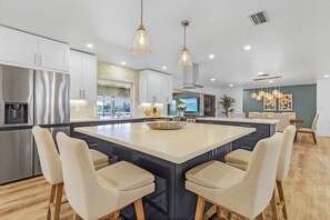 A modern kitchen with a large island, stainless steel appliances, and pendant lighting. - Gorgeous & Spacious 3/3.5, Incredible Water Views! Sleeps 9! (Saint James City)