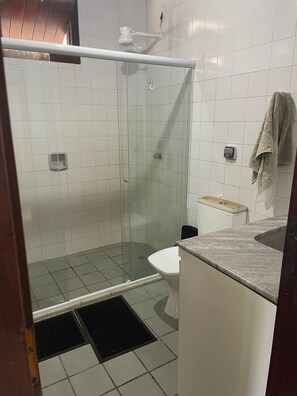 Enjoy a refreshing shower in this bathroom, featuring a handheld showerhead and wall-mounted faucet.