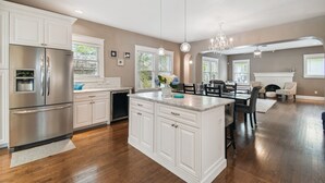 A modern kitchen with white cabinetry, stainless steel appliances, and a central island.