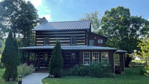 A two-story log cabin with a porch and a covered front porch area. - Spacious In-Town Retreat (Lewisburg)