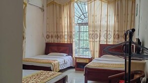 A room with two beds, a window with curtains, a chair, and a desk. - Dongxing Wanwei Jintan Xiangyue Hotel (Dongxing)