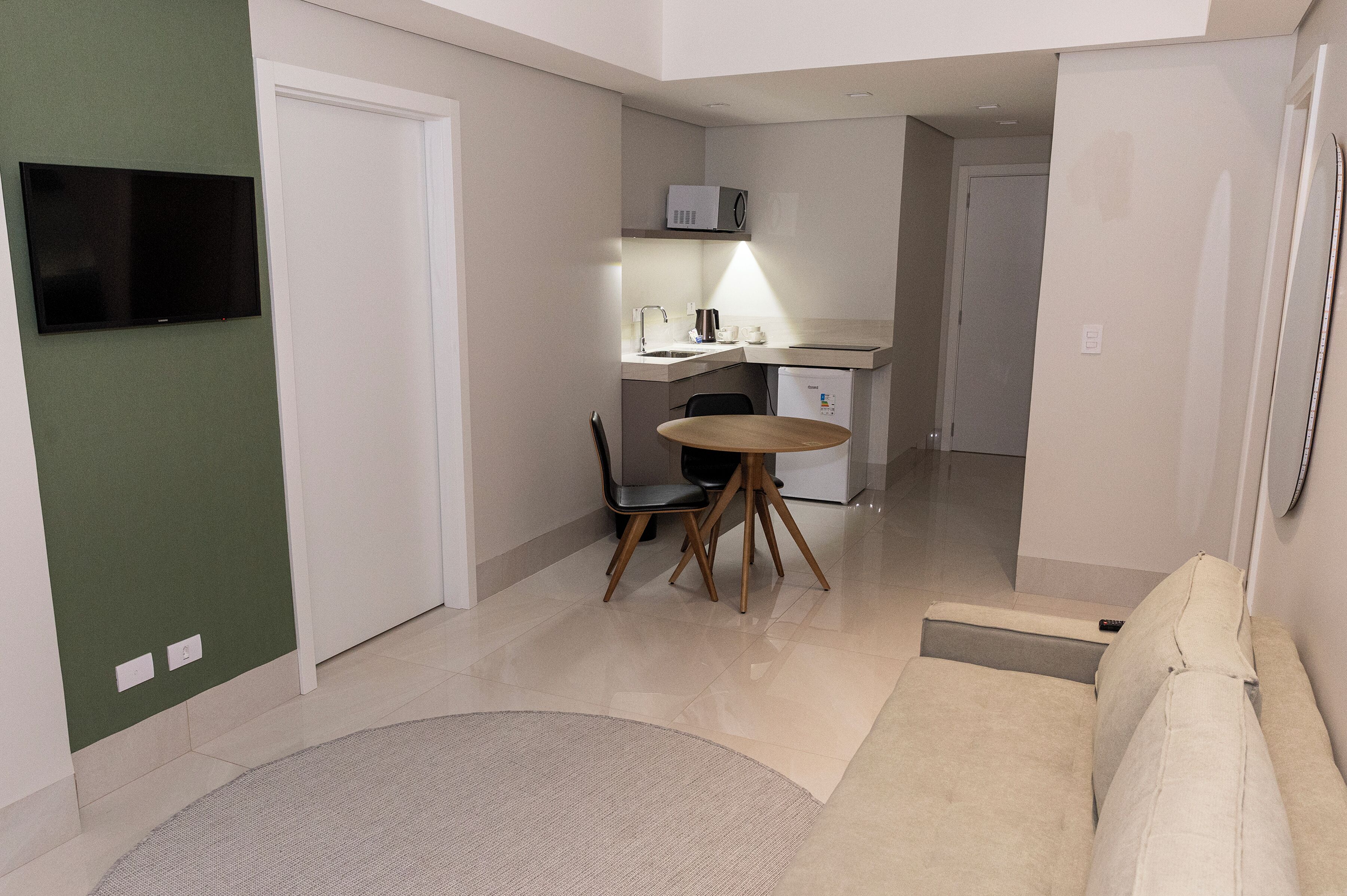 Un espacio habitable compacto con kitchenette, comedor y sofá.