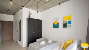 Ein modernes Schlafzimmer mit einem großen Bett, einem Kleiderschrank und Bildern an der Wand.