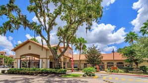 A building with a beige facade, red-tiled roof, and a gated entrance. - Remodeled 3 bed / 2 bath near Disney (Davenport)