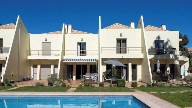 A hotel with a swimming pool, multiple balconies, and a covered outdoor seating area. - Villa Emilly (Albufeira)