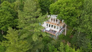 Una casa de varios pisos rodeada por un bosque frondoso.