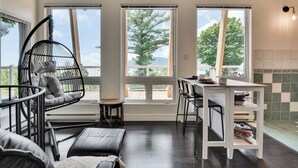 Una cocina moderna con comedor, ventanas amplias y una silla colgante.