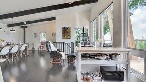 Una cocina moderna con comedor, ventanas amplias y un ventilador de techo.