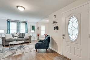 A living room with a sofa, armchair, coffee table, and decorative items. - ATL's NEW Hottest Vibe, Spacious 7-bedroom house (Atlanta)