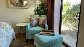 A room with a teal armchair, a small round table, a wooden tray, and a large window with a view of greenery. - 2bd/2ba 1st fl condo Sabino Canyon in Tucson w king/queen pool, pickleball, pets (Tucson)