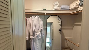 A walk-in closet with a mirror, a wooden bench, and a wicker basket. - 2bd/2ba 1st fl condo Sabino Canyon in Tucson w king/queen pool, pickleball, pets (Tucson)