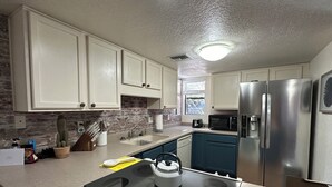 A modern kitchen with white cabinets, a stainless steel refrigerator, a microwave, and a gas stove. - 2bd/2ba 1st fl condo Sabino Canyon in Tucson w king/queen pool, pickleball, pets (Tucson)