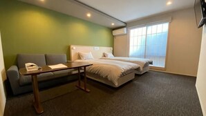 A hotel room with a green wall, a sofa, a bed, a small table, and a window. - Hiz Hotel Gion-Shirakawa (Kyoto)