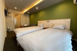 Une chambre d’hôtel avec deux lits, un bureau et une chaise.