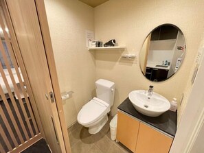 Ein kleines Badezimmer mit Toilette, Waschbecken und Spiegel.