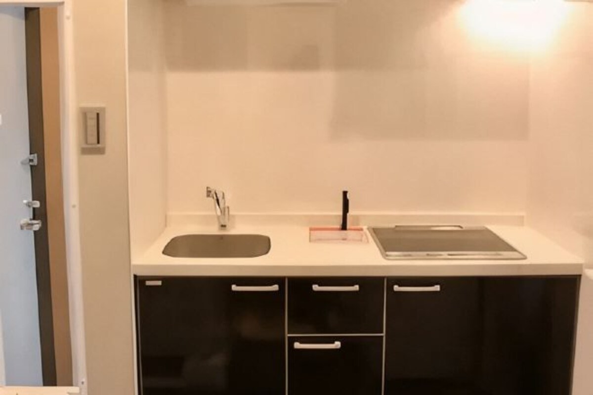 A kitchen with a sink, countertop, and cabinets.