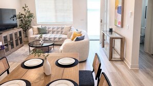 Una sala moderna con sofá, una mesa de centro y un comedor.